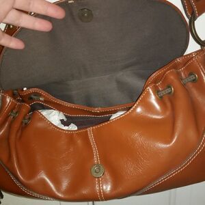 Small tan purse with brown leather tassels